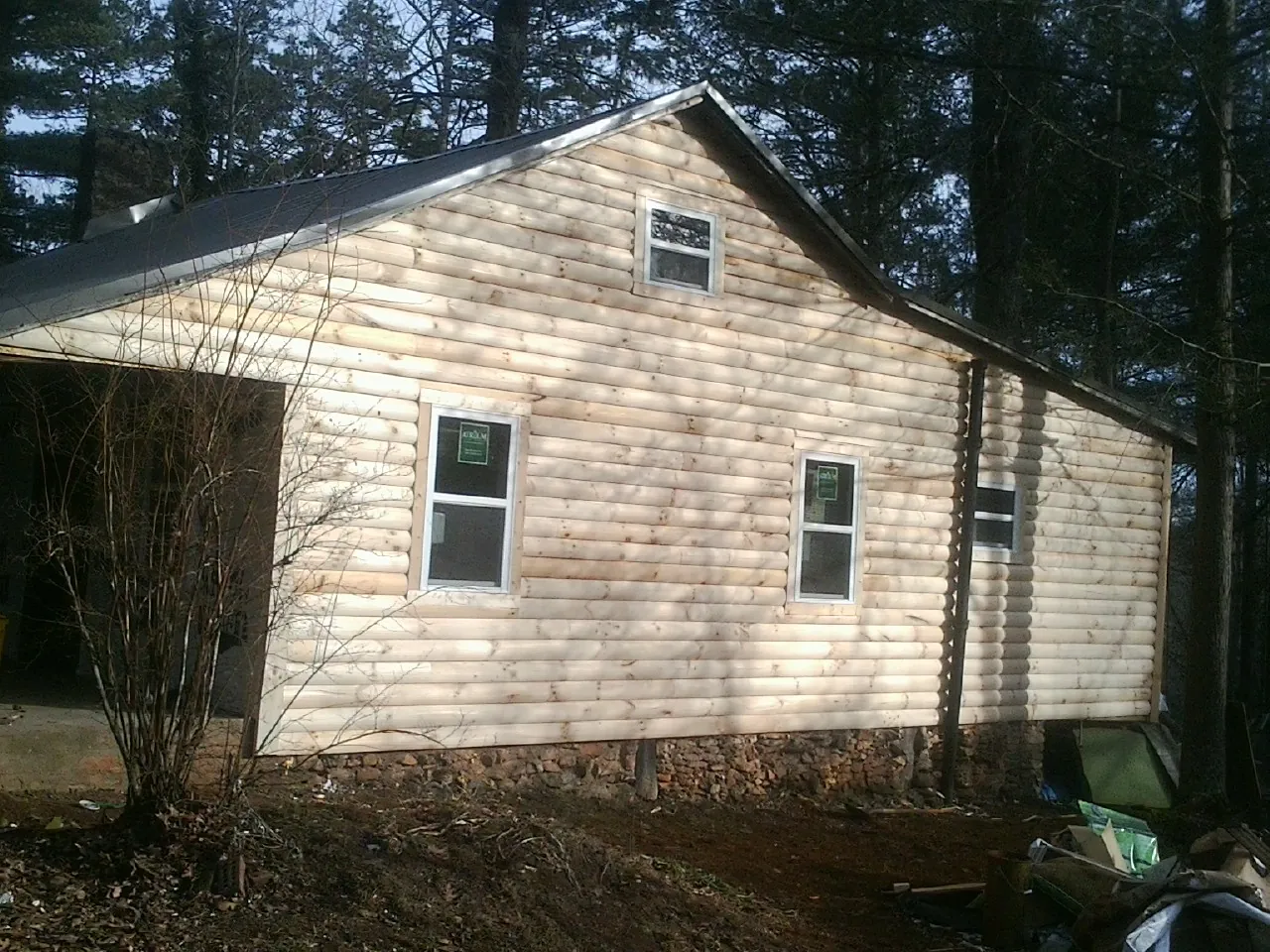 New log siding and dark metal roofing on a gable end in Grand Lake