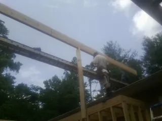 Carpenter setting a ridge beam over a new addition frame — Ice Dam Removal by Roofing Brothers in Grand Lake