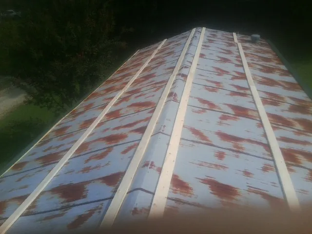 Rusted metal roof panels with new wood purlins before replacement — Storm Damage Roof Repair in Grand Lake by Roofing Brothers