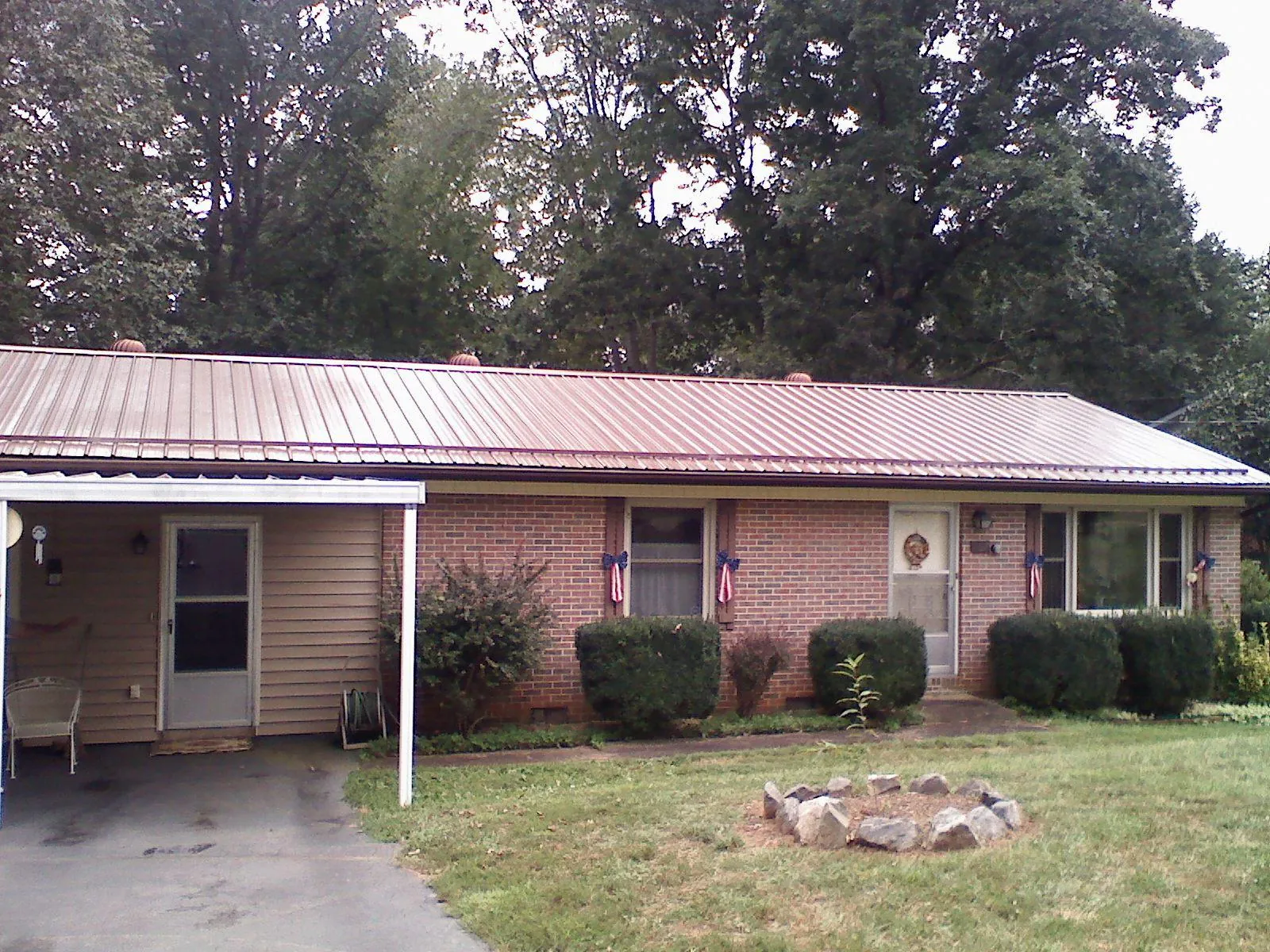 Bronze metal roof and carport on a brick ranch home — Roof Repair work by our crew in Grand Lake